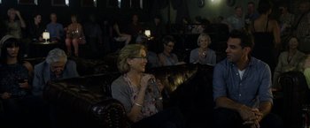 Movie still from “Danny Collins” (2015), directed by Dan Fogelman – A group of people sitting in a room with microphones; Medium shot, Over the shoulder angle