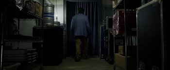 Movie still from “Danny Collins” (2015), directed by Dan Fogelman – A man standing in front of a curtain in a room; Wide shot, Low angle