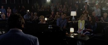 Movie still from “Danny Collins” (2015), directed by Dan Fogelman – A group of people sitting in a room with lights on; Wide shot, Over the shoulder angle