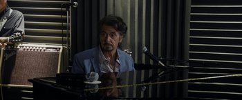 Movie still from “Danny Collins” (2015), directed by Dan Fogelman – A man sitting at a piano in front of microphones; Close Up shot, Over the shoulder angle