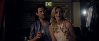 Movie still from “Danny Collins” (2015), directed by Dan Fogelman – A man and a woman standing next to each other holding drinks; Medium shot, Over the shoulder angle