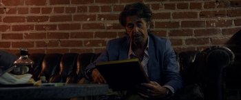 Movie still from “Danny Collins” (2015), directed by Dan Fogelman – A man sitting in front of a laptop computer; Medium shot, Over the shoulder angle