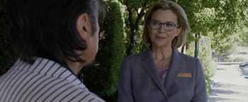 Movie still from “Danny Collins” (2015), directed by Dan Fogelman – A woman wearing a suit and glasses talking to a man; Close Up shot, Over the shoulder angle
