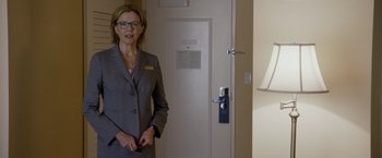 Movie still from “Danny Collins” (2015), directed by Dan Fogelman – A woman standing in front of an open door; Medium shot, Over the shoulder angle