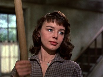 Movie still from “Darby O'Gill and the Little People” (1959), directed by Robert Stevenson – A young woman holding a baseball bat in her hand; Close Up shot, Low angle