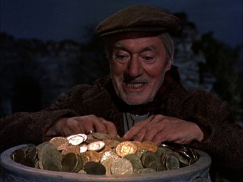 Movie still from “Darby O'Gill and the Little People” (1959), directed by Robert Stevenson – An old man sitting in a bowl of coins; Close Up shot, Low angle