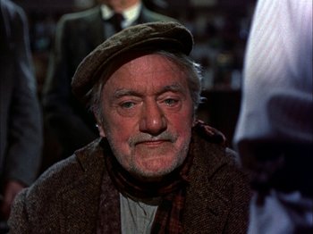 Movie still from “Darby O'Gill and the Little People” (1959), directed by Robert Stevenson – An older man wearing a hat and a scarf; Close Up shot, Over the shoulder angle