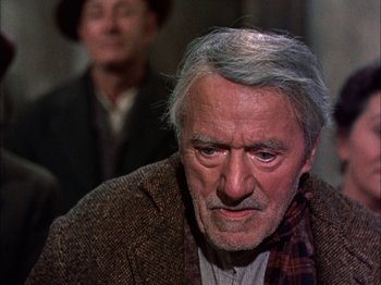 Movie still from “Darby O'Gill and the Little People” (1959), directed by Robert Stevenson – An older man with a beard and a plaid scarf; Close Up shot, Over the shoulder angle