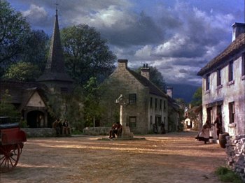 Movie still from “Darby O'Gill and the Little People” (1959), directed by Robert Stevenson – A group of people sitting on the side of a road; Extreme Wide shot, High angle
