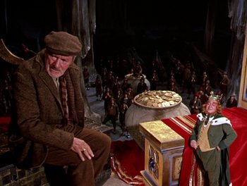 Movie still from “Darby O'Gill and the Little People” (1959), directed by Robert Stevenson – An old man sitting in front of a group of people; Wide shot, High angle