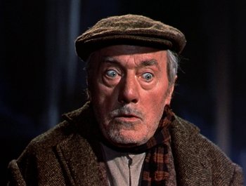 Movie still from “Darby O'Gill and the Little People” (1959), directed by Robert Stevenson – An older man with a hat and a scarf on; Close Up shot, Low angle