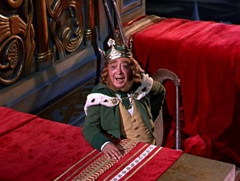 Movie still from “Darby O'Gill and the Little People” (1959), directed by Robert Stevenson – A man wearing a crown sitting at a dinner table; Wide shot, High angle
