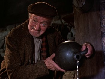 Movie still from “Darby O'Gill and the Little People” (1959), directed by Robert Stevenson – An old man pouring water into a pot; Medium shot, Low angle