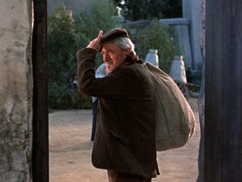Movie still from “Darby O'Gill and the Little People” (1959), directed by Robert Stevenson – An old man wearing a hat and carrying a bag; Medium shot, Low angle
