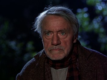 Movie still from “Darby O'Gill and the Little People” (1959), directed by Robert Stevenson – An older man wearing a scarf and a jacket in the dark; Close Up shot, Low angle