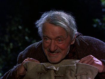 Movie still from “Darby O'Gill and the Little People” (1959), directed by Robert Stevenson – An old man holding a bag with something in it; Close Up shot, High angle