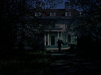 Movie still from “Darby O'Gill and the Little People” (1959), directed by Robert Stevenson – A person walking down a path in front of a building; Extreme Wide shot, Low angle