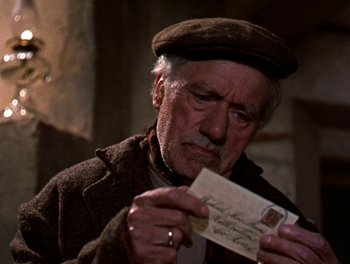 Movie still from “Darby O'Gill and the Little People” (1959), directed by Robert Stevenson – An older man holding a letter in his hands; Close Up shot, High angle