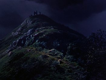 Movie still from “Darby O'Gill and the Little People” (1959), directed by Robert Stevenson – A dark sky with a castle on top of a hill; Extreme Wide shot, Low angle