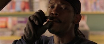 Movie still from “Dark Blue” (2002), directed by Ron Shelton – A man smoking a cigarette while wearing gloves; Close Up shot, Low angle