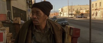 Movie still from “Dark Blue” (2002), directed by Ron Shelton – An older man wearing a brown jacket and a black hat; Medium shot, High angle
