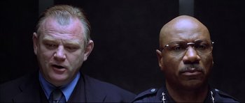 Movie still from “Dark Blue” (2002), directed by Ron Shelton – A couple of men standing next to each other; Close Up shot, Low angle