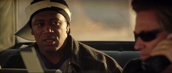 Movie still from “Dark Blue” (2002), directed by Ron Shelton – A man with a hat on sitting in a car; Close Up shot, Over the shoulder angle