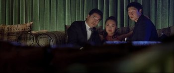 Movie still from “Dark Blue” (2002), directed by Ron Shelton – A man and a woman sitting next to each other on a couch; Medium shot, Low angle
