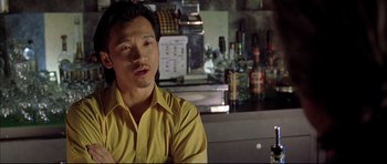Movie still from “Dark Blue” (2002), directed by Ron Shelton – A man sitting at a counter in front of a bar; Close Up shot, Low angle