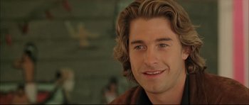 Movie still from “Dark Blue” (2002), directed by Ron Shelton – A man with long blonde hair and blue eyes smiling; Close Up shot, Over the shoulder angle