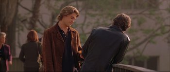 Movie still from “Dark Blue” (2002), directed by Ron Shelton – A man in a brown jacket is shaking hands with another man in a brown jacket; Medium shot, Over the shoulder angle