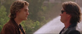 Movie still from “Dark Blue” (2002), directed by Ron Shelton – A man standing in front of a water fountain; Close Up shot, Over the shoulder angle