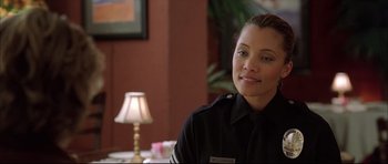 Movie still from “Dark Blue” (2002), directed by Ron Shelton – A woman wearing a uniform sitting in front of a lamp; Close Up shot, Over the shoulder angle