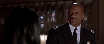 Movie still from “Dark Blue” (2002), directed by Ron Shelton – A man in a uniform sitting in front of a woman; Close Up shot, Low angle