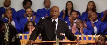 Movie still from “Dark Blue” (2002), directed by Ron Shelton – A man that is giving a speech in front of a crowd; Medium shot, Low angle