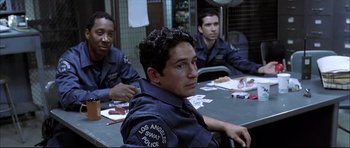 Movie still from “Dark Blue” (2002), directed by Ron Shelton – A group of men sitting around a table; Medium shot, High angle