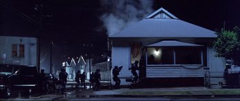Movie still from “Dark Blue” (2002), directed by Ron Shelton – A group of men in black suits are standing in front of a house; Extreme Wide shot, Low angle
