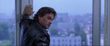 Movie still from “Dark Blue” (2002), directed by Ron Shelton – A person wearing a leather jacket near a window; Close Up shot, Low angle