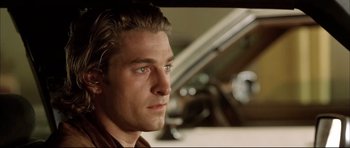 Movie still from “Dark Blue” (2002), directed by Ron Shelton – A person with a car in the background; Close Up shot, Low angle