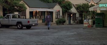 Movie still from “Dark Blue” (2002), directed by Ron Shelton – A man walking down the street in front of a building; Wide shot, Low angle