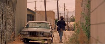 Movie still from “Dark Blue” (2002), directed by Ron Shelton – A man walking down a street next to a parked car; Wide shot, Low angle