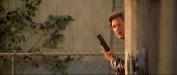 Movie still from “Dark Blue” (2002), directed by Ron Shelton – A man holding a gun up to his face; Medium shot, Low angle