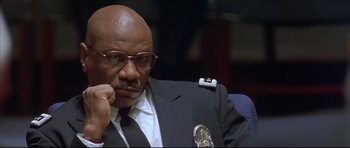Movie still from “Dark Blue” (2002), directed by Ron Shelton – A man in a suit and tie sitting in a chair; Close Up shot, Low angle