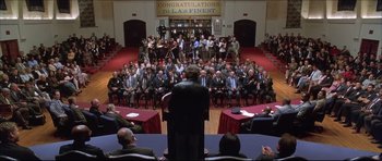 Movie still from “Dark Blue” (2002), directed by Ron Shelton – A group of people sitting in front of microphones in a room; Extreme Wide shot, High angle