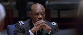 Movie still from “Dark Blue” (2002), directed by Ron Shelton – A man in a uniform sitting down with his eyes closed; Close Up shot, Low angle