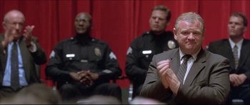 Movie still from “Dark Blue” (2002), directed by Ron Shelton – A group of men sitting next to each other in front of a red curtain; Close Up shot, Low angle