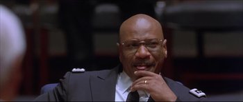 Movie still from “Dark Blue” (2002), directed by Ron Shelton – A man in a suit and tie with his hand under his chin; Close Up shot, Low angle