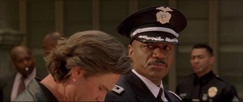 Movie still from “Dark Blue” (2002), directed by Ron Shelton – A man in a police uniform and a woman in a white dress; Close Up shot, Low angle