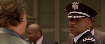 Movie still from “Dark Blue” (2002), directed by Ron Shelton – A man in a police uniform is looking at the camera; Close Up shot, Low angle