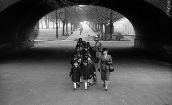 Movie still from “Darling” (1965), directed by John Schlesinger – A group of people walking down a street; Wide shot, High angle